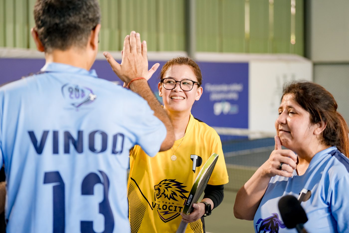 Woman high-fiving across the pickleball net